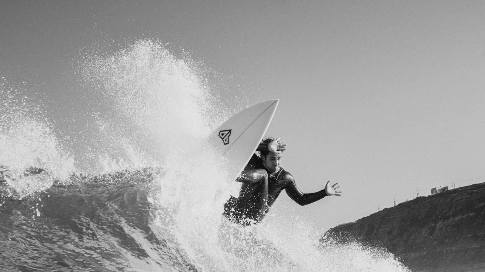 surfer performing a maneuver with an onboard surfboard