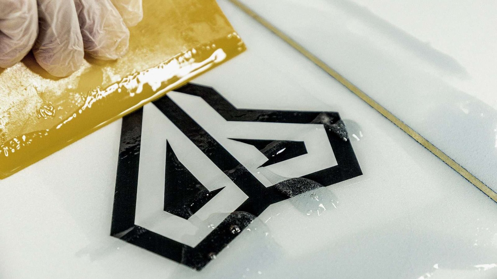 Logo being applied to a surfboard