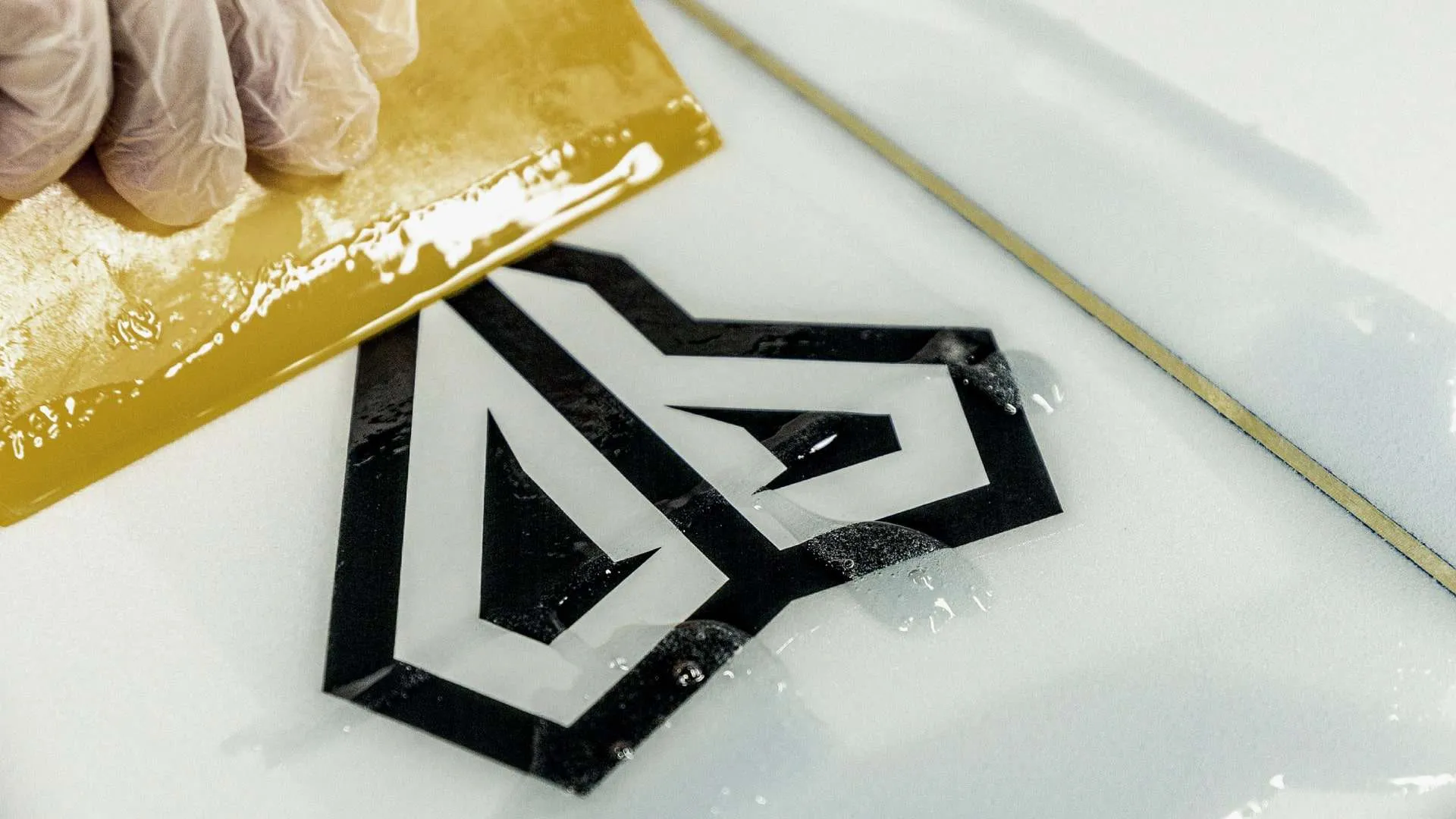 Logo being applied to a surfboard
